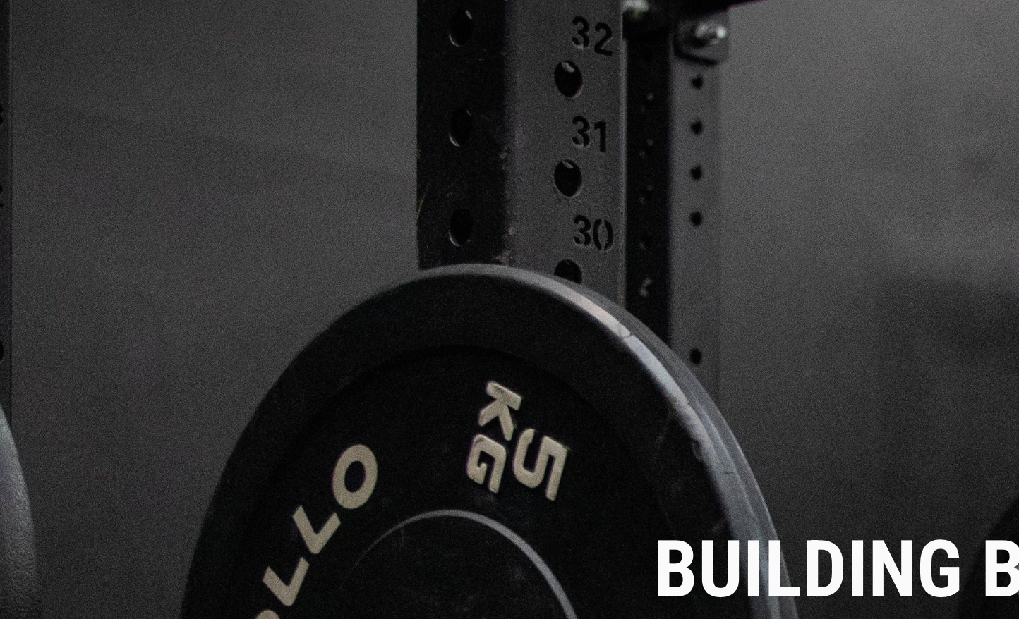 Close-up of a barbell with weight plates on a dark background