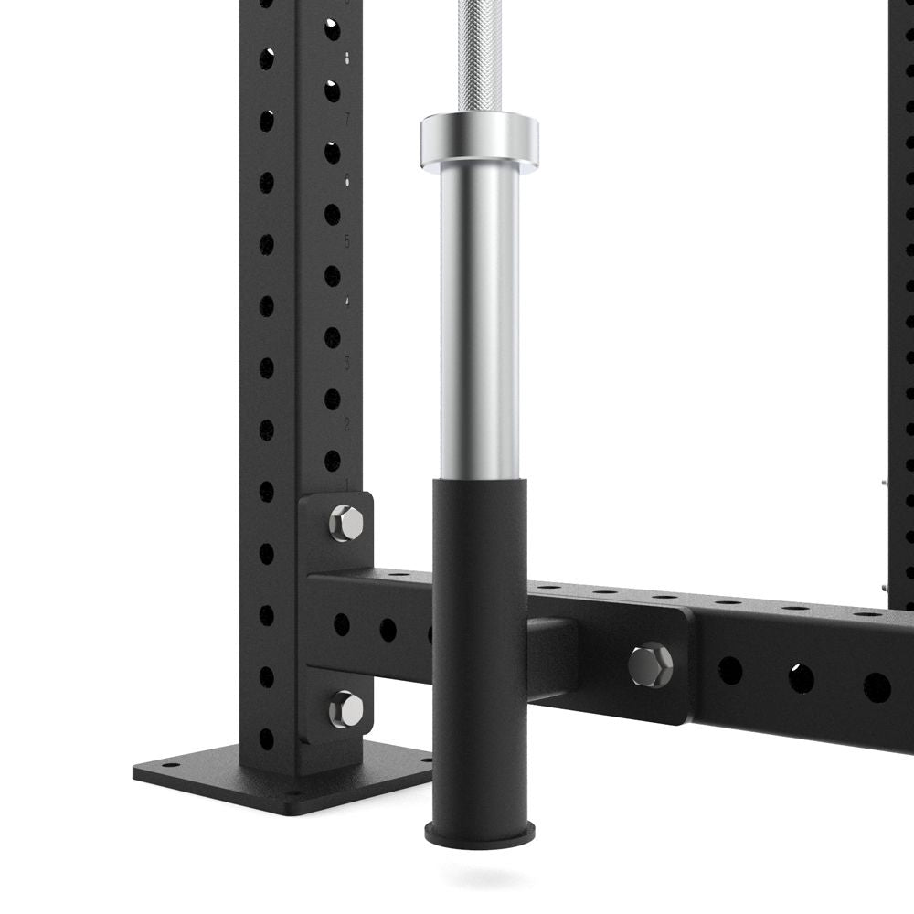 Close-up of a black metal power rack with a silver bar on a white background